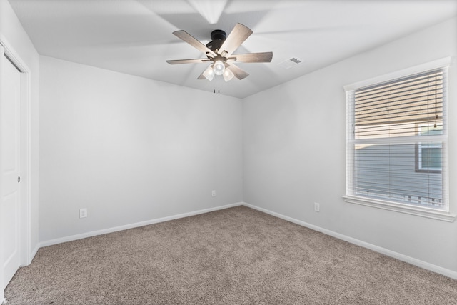 carpeted spare room featuring ceiling fan