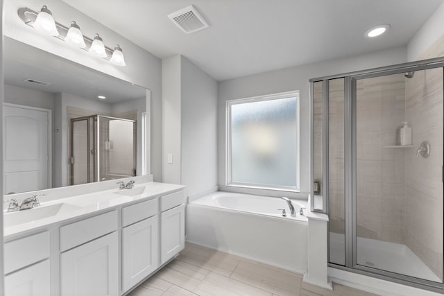 bathroom with tile patterned flooring, vanity, and separate shower and tub