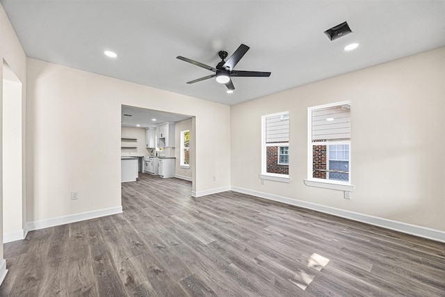 unfurnished living room with hardwood / wood-style flooring and ceiling fan