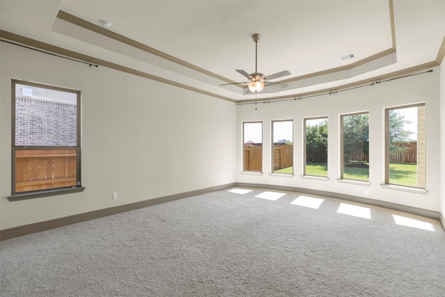 unfurnished room featuring ceiling fan, a raised ceiling, crown molding, and carpet flooring