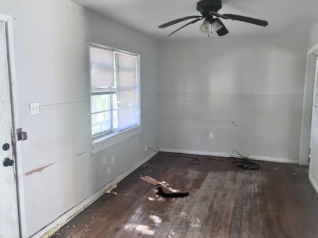 spare room with dark hardwood / wood-style flooring and ceiling fan