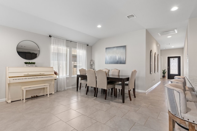 dining room with vaulted ceiling and light tile patterned flooring