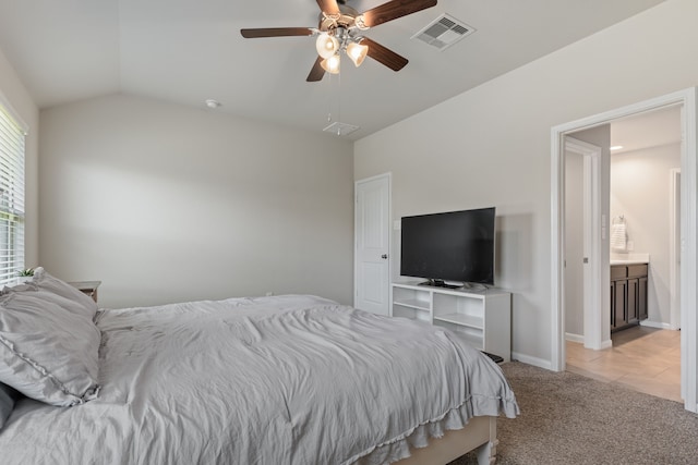 bedroom with connected bathroom, ceiling fan, light carpet, and vaulted ceiling