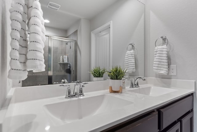 bathroom featuring vanity and an enclosed shower