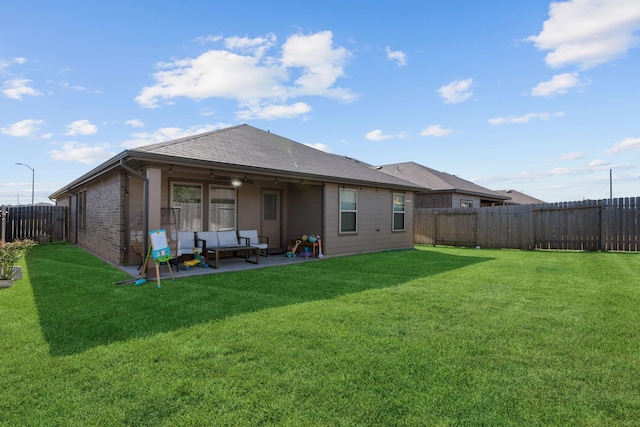 back of property with an outdoor living space, a yard, ceiling fan, and a patio