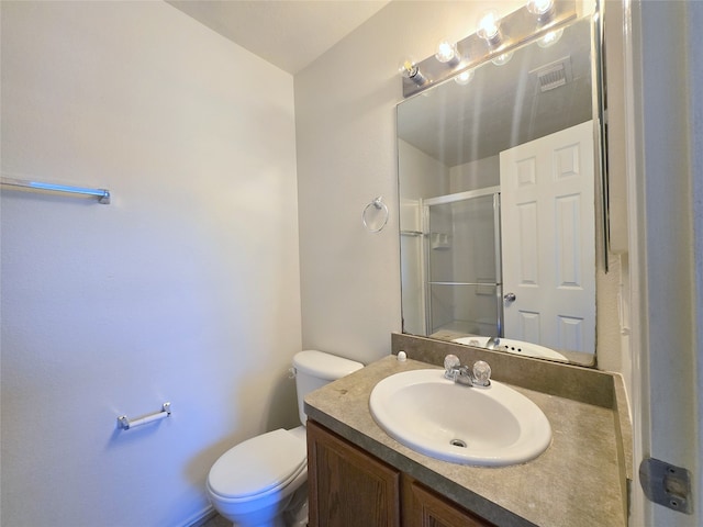 bathroom with vanity, toilet, and a shower with shower door