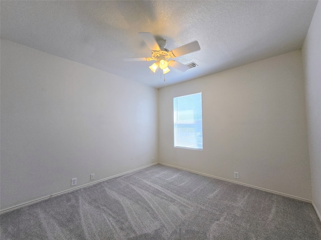 carpeted empty room with ceiling fan and a textured ceiling