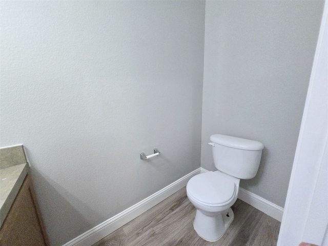 bathroom with hardwood / wood-style floors, vanity, and toilet