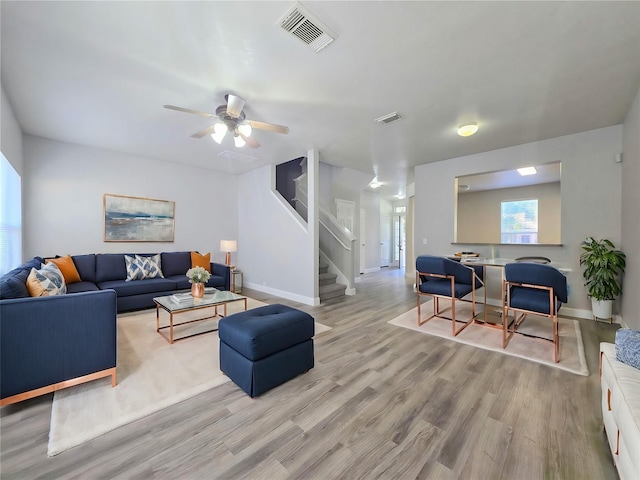 living room featuring ceiling fan and light hardwood / wood-style flooring