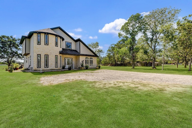 rear view of house featuring a lawn