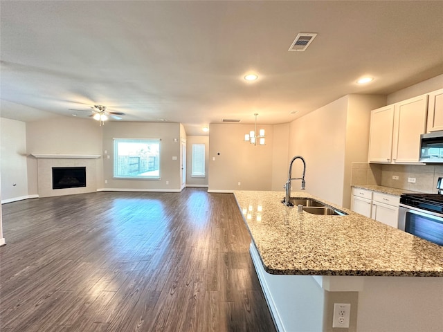 kitchen featuring hanging light fixtures, sink, white cabinetry, appliances with stainless steel finishes, and dark hardwood / wood-style flooring