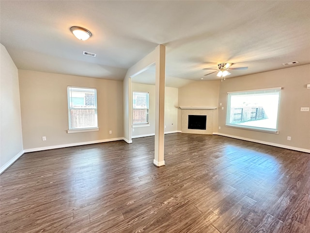 unfurnished living room with ceiling fan, plenty of natural light, and dark wood-type flooring