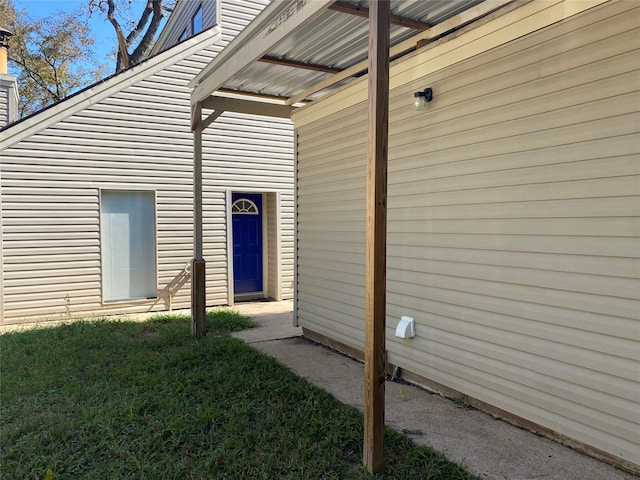 entrance to property featuring a lawn