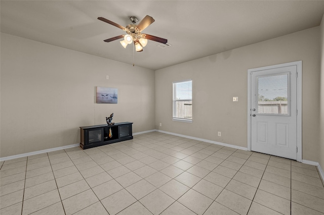 unfurnished living room featuring ceiling fan and light tile patterned floors