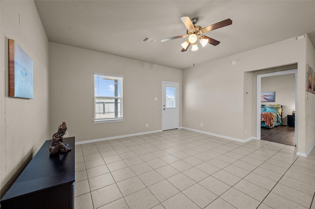 tiled empty room featuring ceiling fan