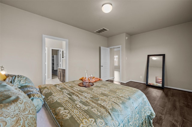 bedroom featuring connected bathroom and dark hardwood / wood-style flooring