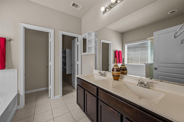 bathroom featuring tile patterned floors, a tub to relax in, and vanity