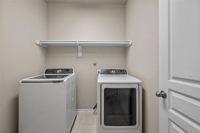 laundry room featuring washing machine and clothes dryer and light tile patterned floors