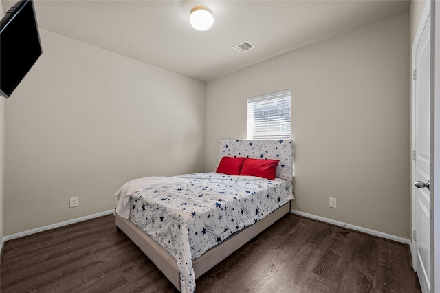 bedroom with dark hardwood / wood-style floors