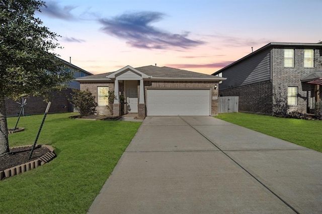 view of front of property with a garage and a yard