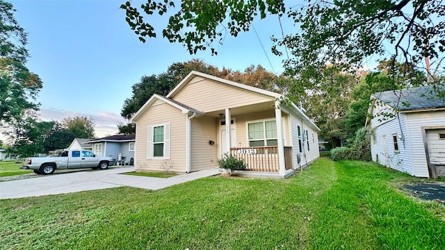 bungalow with a garage, a front lawn, and covered porch