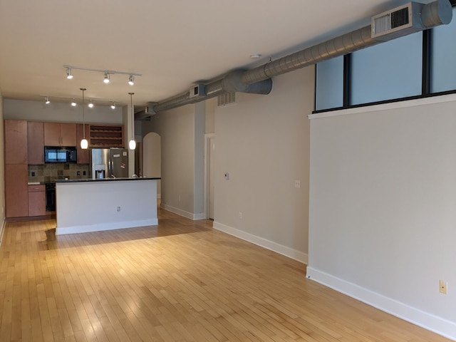 kitchen with decorative backsplash, black appliances, decorative light fixtures, and light hardwood / wood-style floors