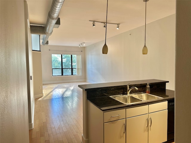 kitchen featuring pendant lighting, dishwasher, white cabinets, sink, and light hardwood / wood-style flooring