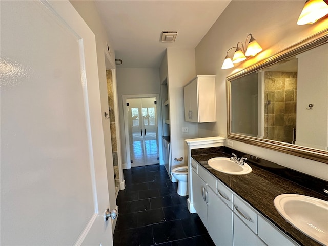 bathroom featuring vanity, toilet, and a tile shower