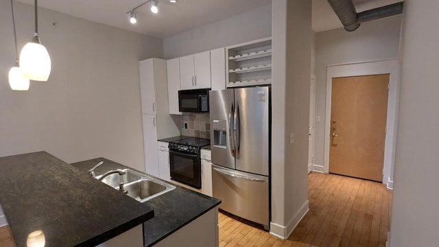 kitchen featuring sink, hanging light fixtures, decorative backsplash, white cabinets, and black appliances