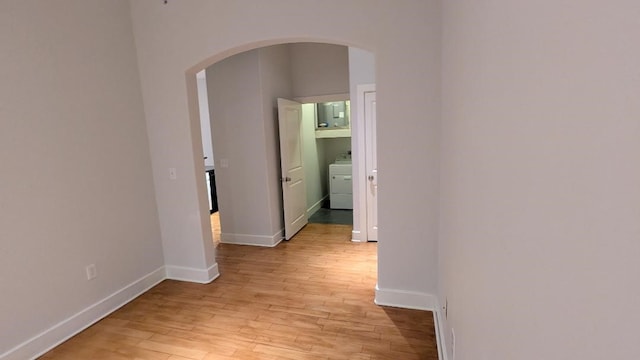 hallway with washer / dryer and light wood-type flooring