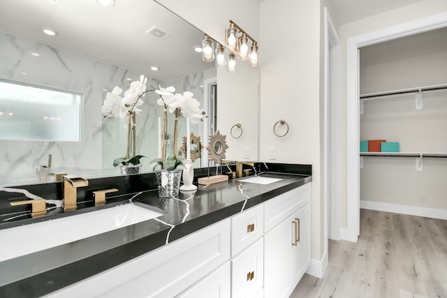 bathroom featuring hardwood / wood-style flooring, vanity, and walk in shower