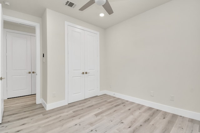 unfurnished bedroom featuring ceiling fan, a closet, and light hardwood / wood-style flooring