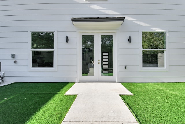 entrance to property with a yard and french doors