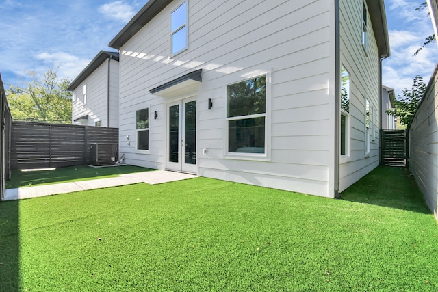 rear view of house featuring a yard and central air condition unit