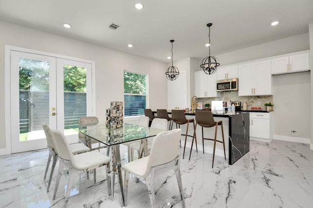 dining area with an inviting chandelier and french doors