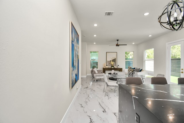 dining room with a healthy amount of sunlight and ceiling fan with notable chandelier