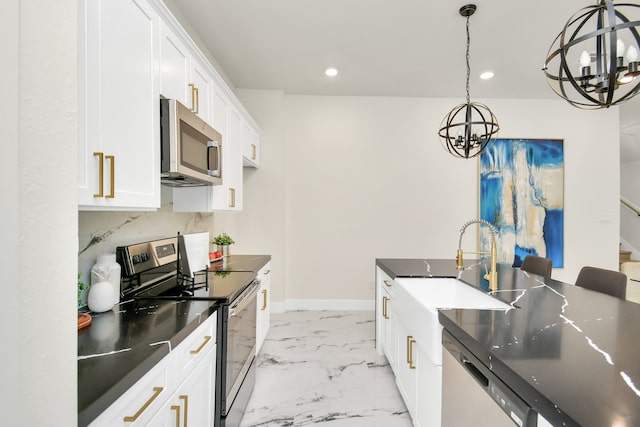 kitchen featuring appliances with stainless steel finishes, decorative light fixtures, sink, white cabinets, and a notable chandelier