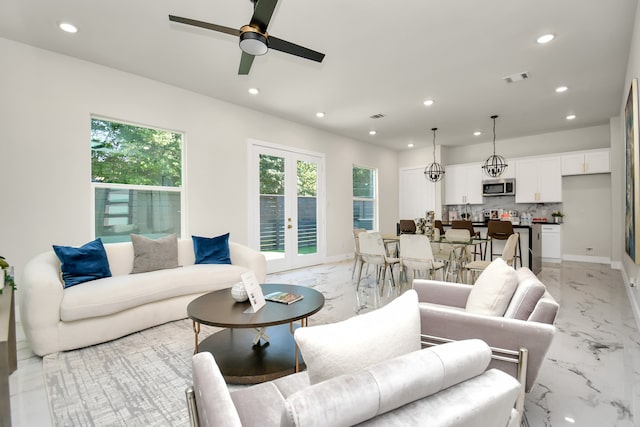 living room featuring ceiling fan and french doors