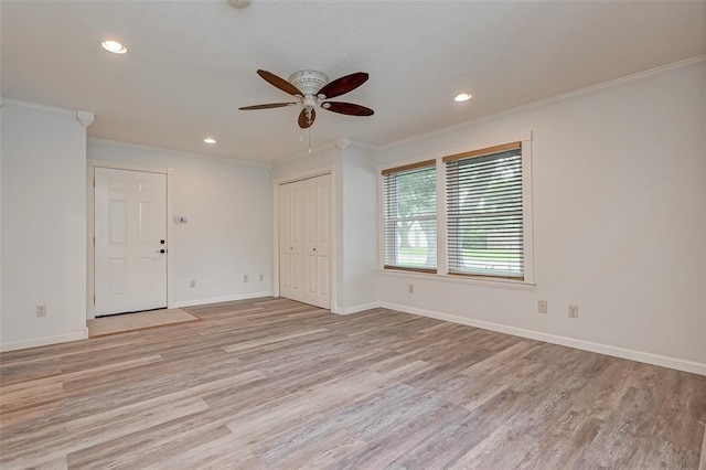 spare room featuring light hardwood / wood-style floors, ornamental molding, and ceiling fan