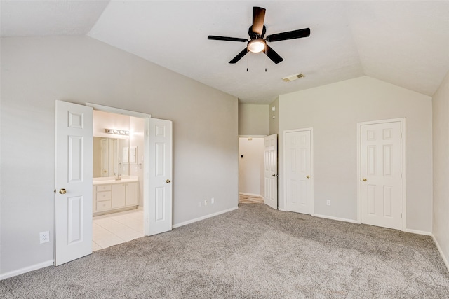 unfurnished bedroom with ceiling fan, light colored carpet, and vaulted ceiling