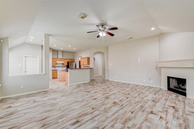 unfurnished living room featuring light hardwood / wood-style floors, lofted ceiling, and ceiling fan