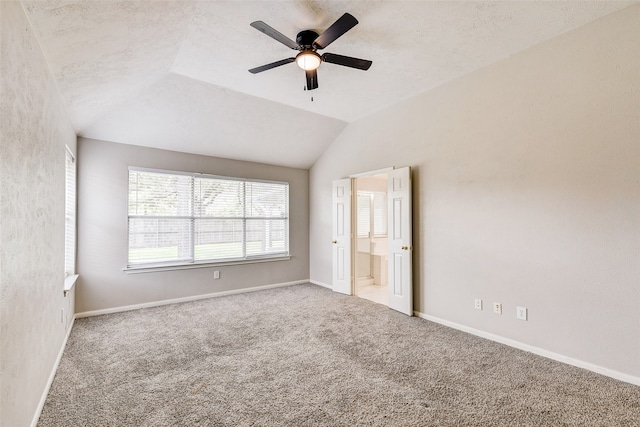 unfurnished bedroom with ceiling fan, lofted ceiling, and carpet flooring