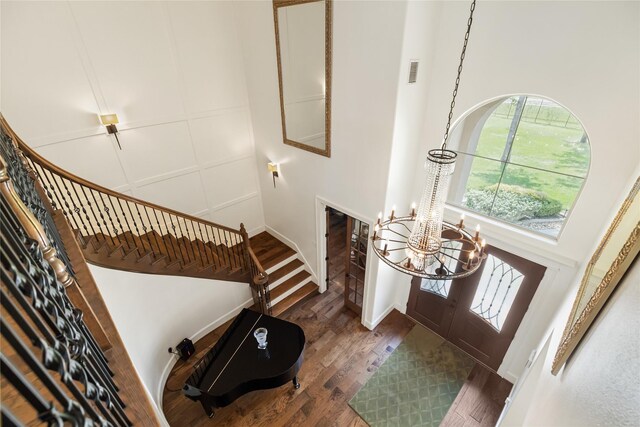 entryway featuring dark hardwood / wood-style flooring, a chandelier, and a high ceiling