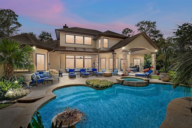 back house at dusk featuring a swimming pool with hot tub, an outdoor living space, a patio, and ceiling fan