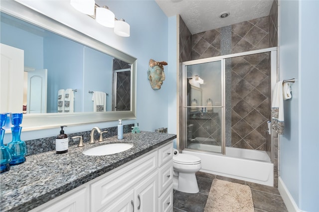 bathroom featuring baseboards, bath / shower combo with glass door, toilet, a textured ceiling, and vanity