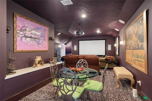 cinema room featuring lofted ceiling and a textured ceiling