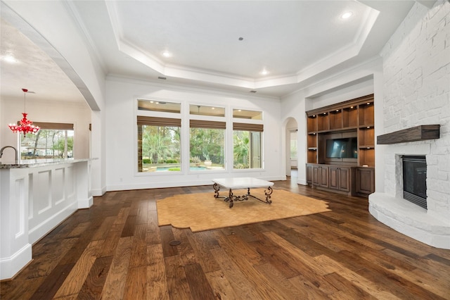 unfurnished living room featuring crown molding, a raised ceiling, and dark wood-style flooring