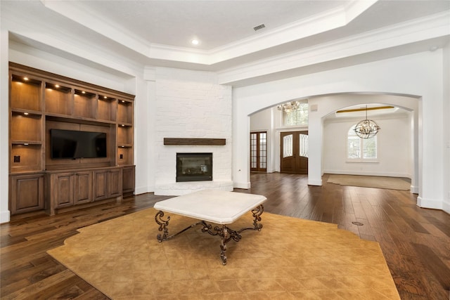 living room with french doors, an inviting chandelier, ornamental molding, dark hardwood / wood-style flooring, and a tray ceiling