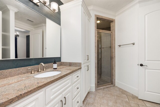 bathroom with a shower with door, vanity, ornamental molding, and tile patterned floors