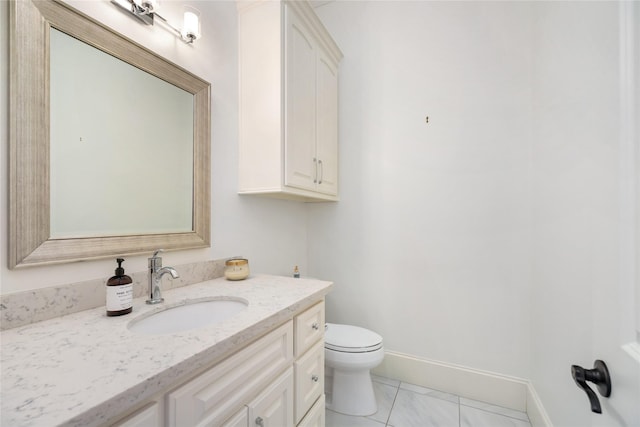 bathroom featuring baseboards, vanity, and toilet